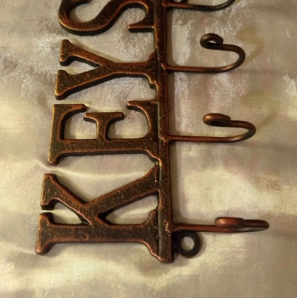 Metal Wall Mounted Key Rack With A Beautiful Black And Bronze Finish.